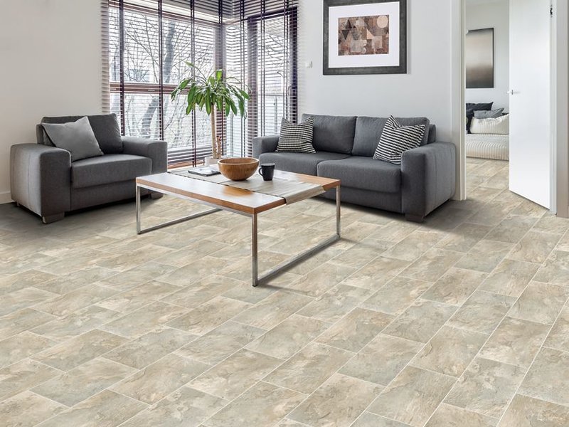Tile flooring in a living room with grey couches.
